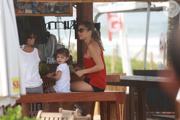 Grazi Massafera parou no quiosque com a filha, Sofia, e a amiga Anna Lima para beber uma água de coco após praticar exercícios na praia