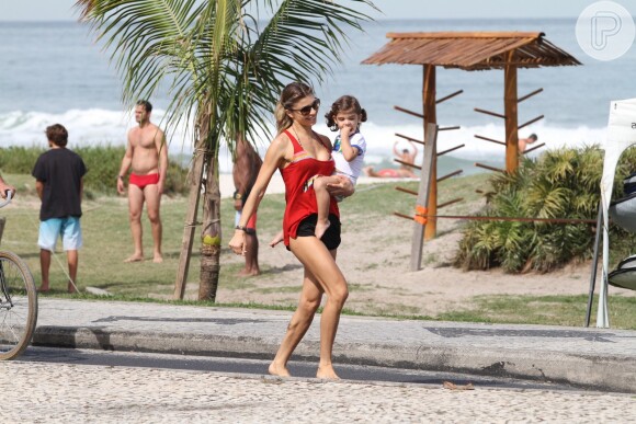 Grazi Massafera deixa a praia da Barra com a filha, Sofia, no colo