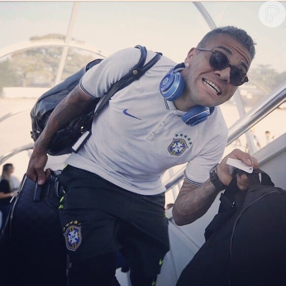Bem-humorado, Daniel Alves abre um sorriso ao embarcar para jogar contra a Seleção de Camarões
