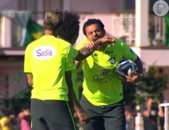 Fred brinca de morder braço de Marcelo fazendo referência à ação do jogador Luis Suárez durante o jogo entre Uruguai e Itália