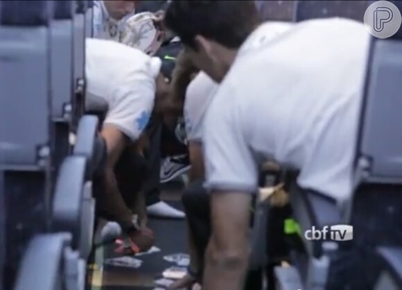 Os atletas jogam cartas no piso do avião na falta de um espaço mais apropriado