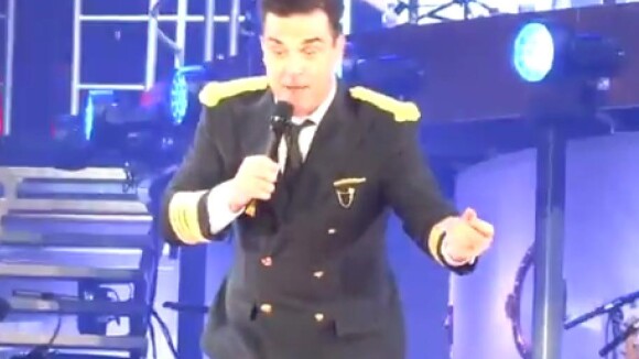 Robbie Williams quebra braço de fã ao cair do palco durante show na Inglaterra
