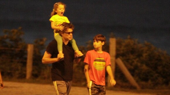 Fábio Assunção carrega caçula nos ombros em passeio com os filhos na praia