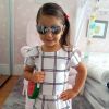 Maria Flor, filha de Deborah Secco e Hugo Moura, usou macaquinho xadrez com detalhe de lacinho na manga, óculos espelhados e bolsa de melancia
