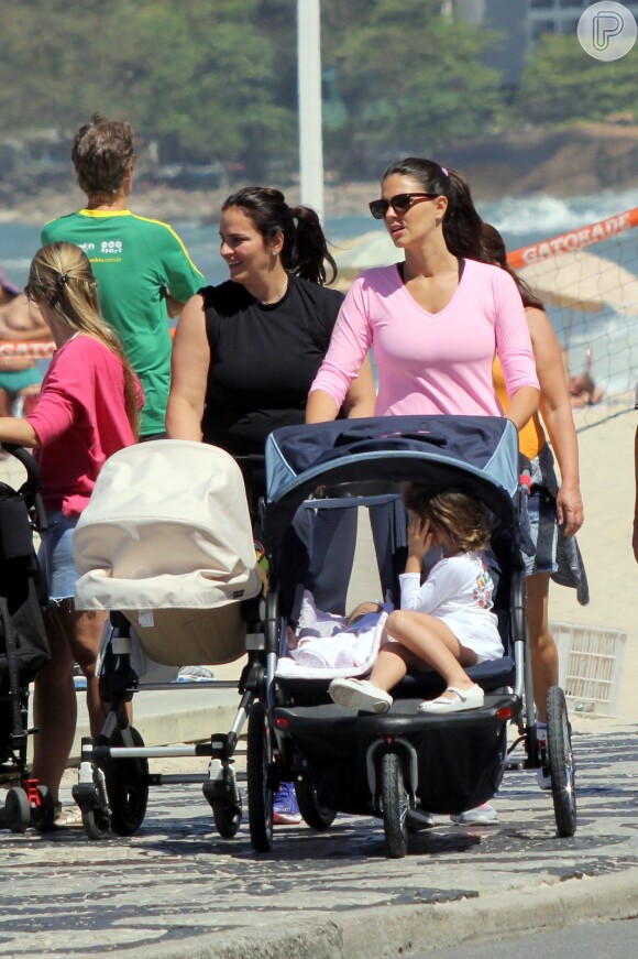 Daniella Sarahyba passeou pelo calçadão da praia do Leblon, na Zona Sul do Rio, acompanhada pelas filhas Gabriela, de 3 anos, e Rafaella, de apenas 5 meses. Acomodadas em um carrinho geralmente usado para gêmeos, as meninas curtiram o sol da manhã na companhia da modelo