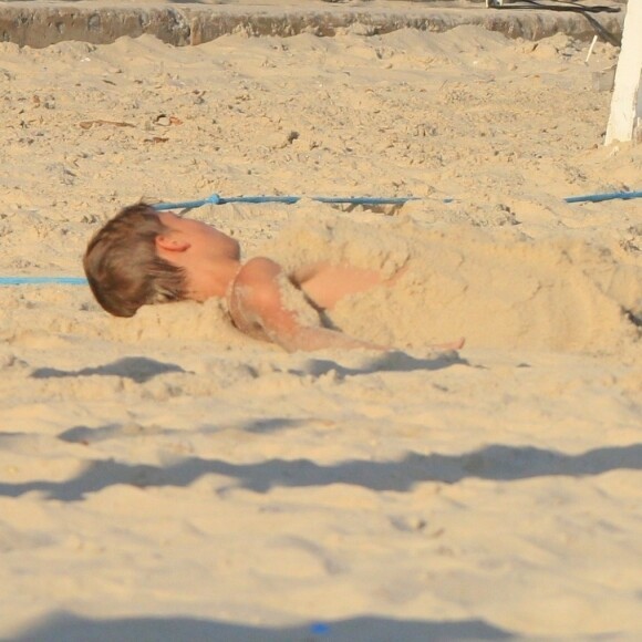 Os gêmeos João e Francisco brincaram de se enterrar na areia enquanto Rodrigo Hilbert jogava