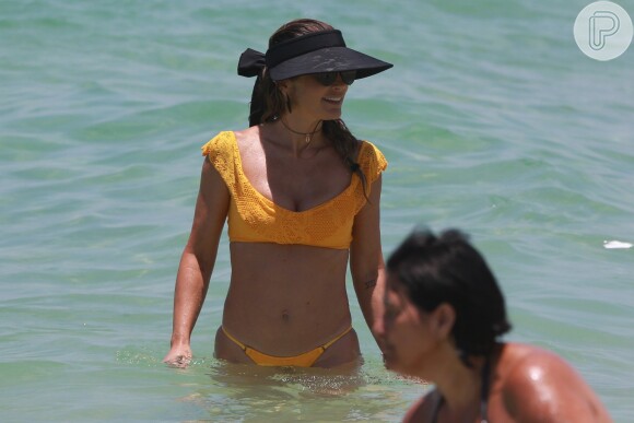 O modelo amarelo e com decote de ombro a ombro valorizou a silhueta de Flávia Alessandra
