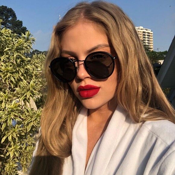 O batom vermelho faz um look de verão glam com o óculos escuros