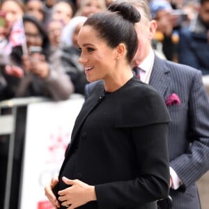 Sem clutch, Meghan Markle ficou com as mãos livres e segurou a barriga nas fotos