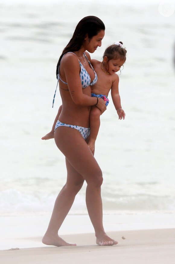 Yanna Lavigne carrega a filha no colo e brinca com a menina na praia