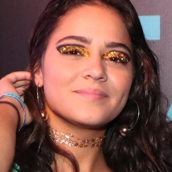 Giullia Buscacio usou delineador vazado, sombra em tom de amarelo e muito glitter dourado na maquiagem dos olhos em camarote no Carnaval do Rio