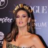 Camila Queiroz combinou um acessório na cabeça, joias Andrea Conti e um leque descontruído no Baile da Vogue, neste sábado, dia 23 de março, em São Paulo