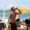 Carmo Dalla Vecchia, no ar em 'Império', se exercita em orla na praia no Rio e toma água para se hidratar durante caminhada