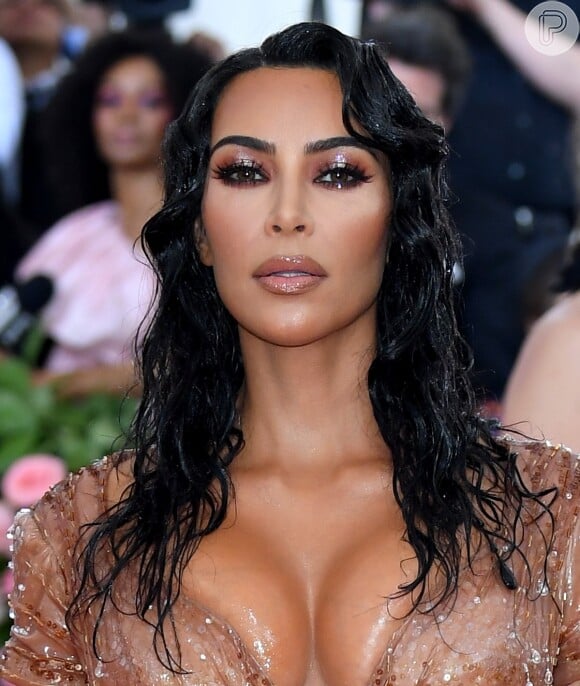 Detalhe da maquiagem de Kim Kardashian com efeito glossy e wet hait como stying