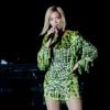 Beyoncé a bordo de um vestido Tom Ford com franjas todo brilhoso de animal print com fundo verde neon