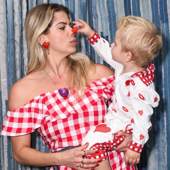 Karina Bacchi posou com o filho, Enrico, no colo em festa junina beneficente