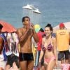 Entre um beijo e outro, Marcello Melo Jr. a namorada, Caroline Alves, se refrescaram no chuveirão da praia