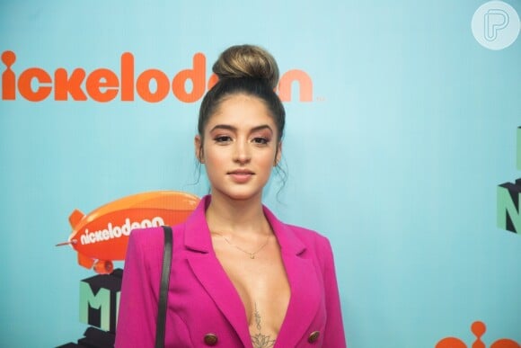 Thaylise Pivato, ex-namorada do cantor Vitão, fez sua estreia no tapete laranja do evento com um maxiblazer pink, sem sutiã, e short repleto de brilho
