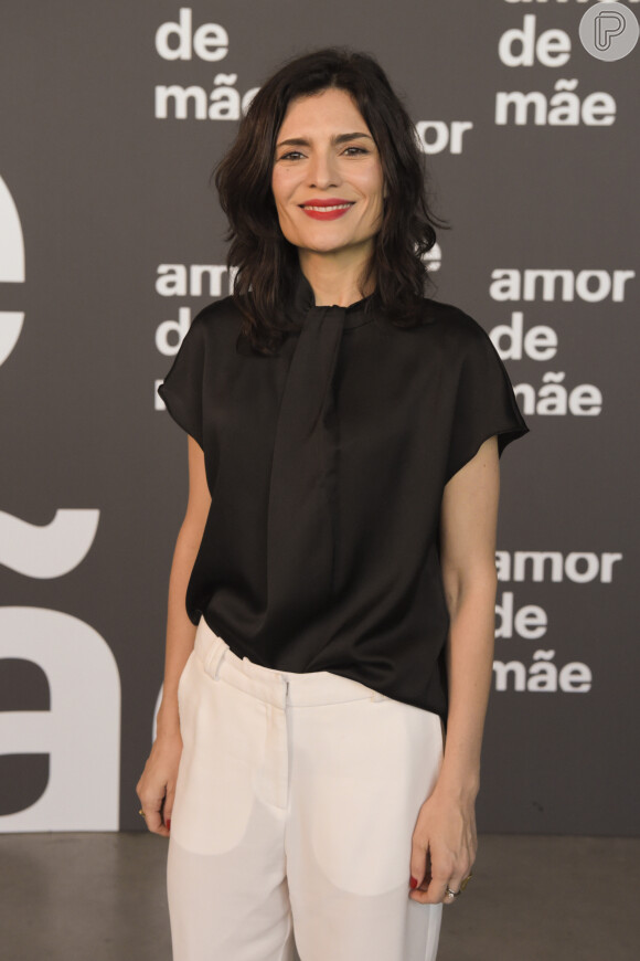 A atriz Arieta Corrêa apostou na tendência do conjuntinho com blusa de cetim preta e calça branca soltinha