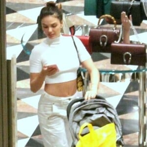 Isis Valverde deixa barriga à mostra com calça mom jeans e cropped de gola alta em ida ao shopping