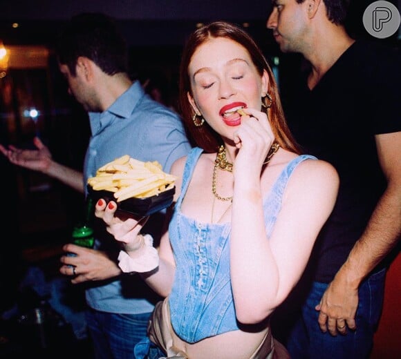 Marina Ruy Barbosa escolheu uma blusa corselet e deixou a barriga à mostra em foto comendo batata frita