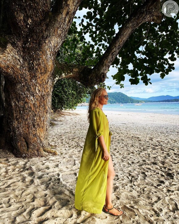 Angélica usou maiô com estampa de morango em praia e foi fotografada pelo marido, Luciano Huck