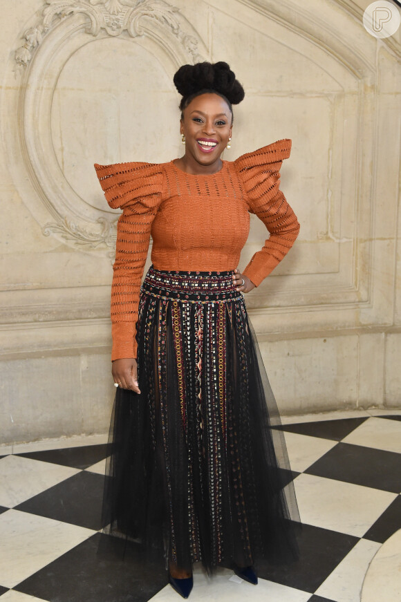 Trends da moda: usando saia com transparência, blusa de ombros volumosos, Chimamanda Adichie, escritora feminista nigeriana, marcou presença no desfile da Dior no Musée Rodin, em Paris