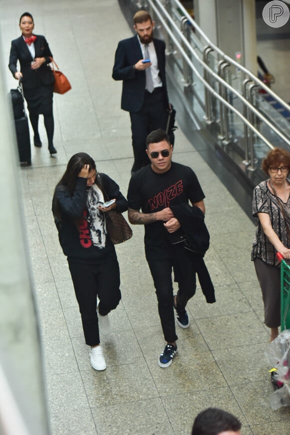 Felipe Araújo e a namorada, Estella Defant, foram fotografados deixando aeroporto de SP