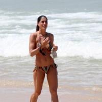 Sem Eduardo Moscovis, Cynthia Howlett nada na praia de Ipanema exibindo corpão
