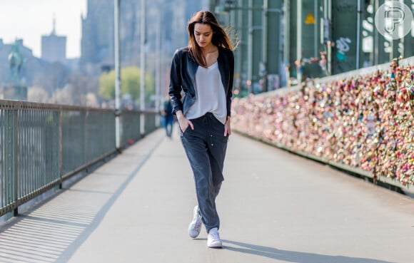 Versatilidade da calça jogger num look básico e interessante com tênis, blusa branca e jaqueta de couro