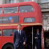 De terno e gravata, Príncipe Harry anda de ônibus no London's Poppy Day