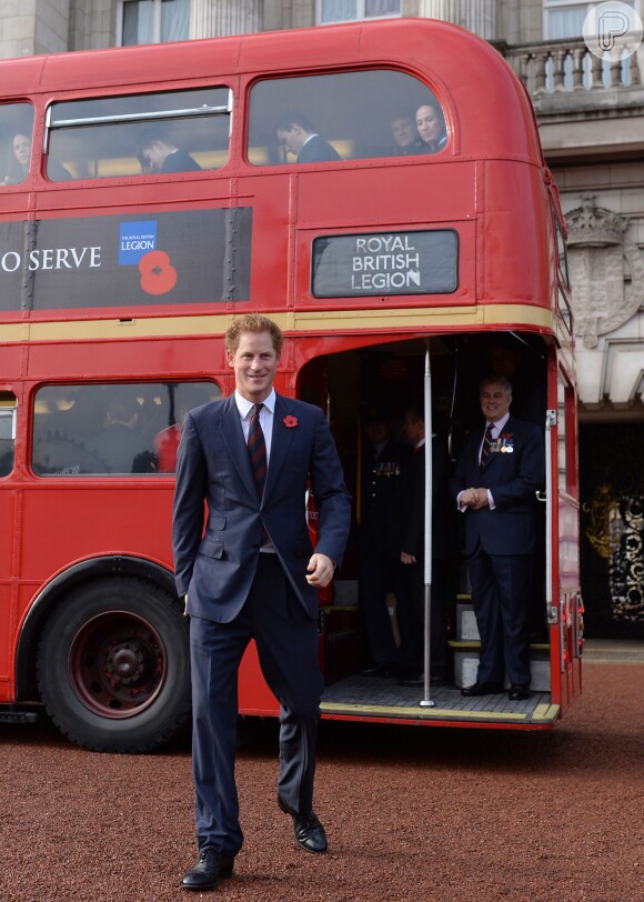 De terno e gravata, Príncipe Harry anda de ônibus no London's Poppy Day