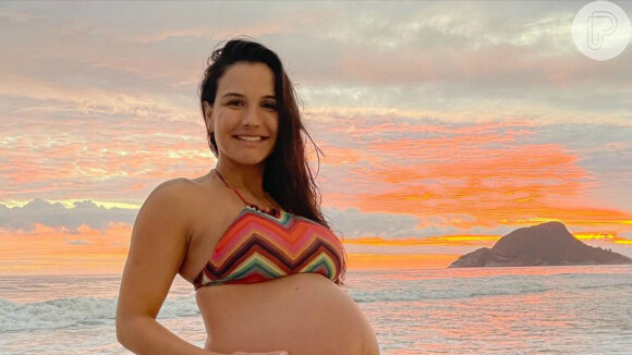 Kyra Gracie, no fim da gravidez, posou segurando a barriga em dia de praia