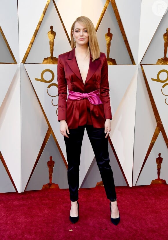 O blazer vinho com calça preta e uma faixa para marcar a cintura foi a aposta de Emma Stone na premiação de 2018. Para quem é fã de calça, uma boa inspiração para festas