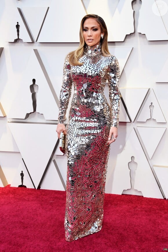 Muito brilho! Essa foi a aposta de Jennifer Lopez no Oscar 2019. O vestido prata com mangas e gola alta e corte reto roubou a cena
