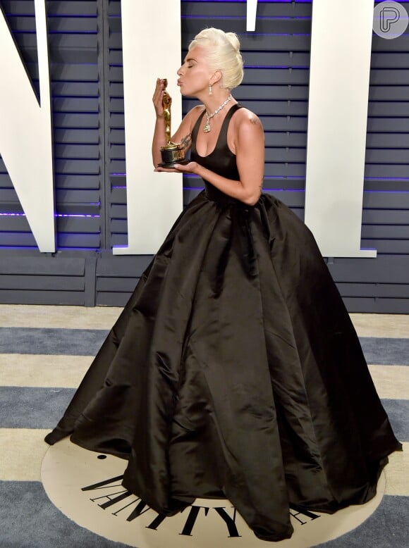 Lady Gaga lindíssima num vestido preto com saia bem armada e acinturado no Oscar 2029. Pouca informação e muita elegância