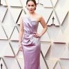 O vestido de Emilia Clarke no Oscar 2019 foi um lilás perolado, no mood candy colors. Detalhe para o recorte assimétrico e geométrico do decote sem alças