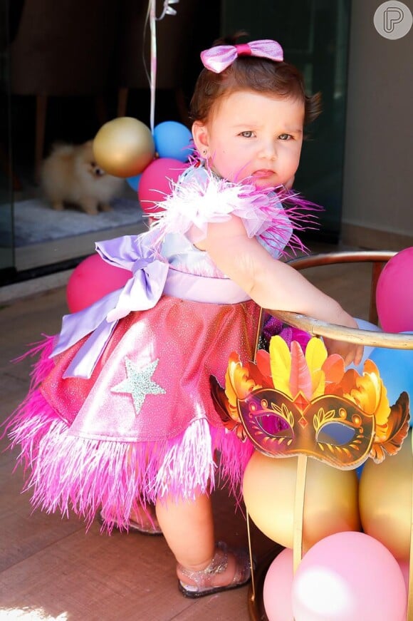 Filha de Zé Neto usa vestido rosa com plumas, laços e estrelas