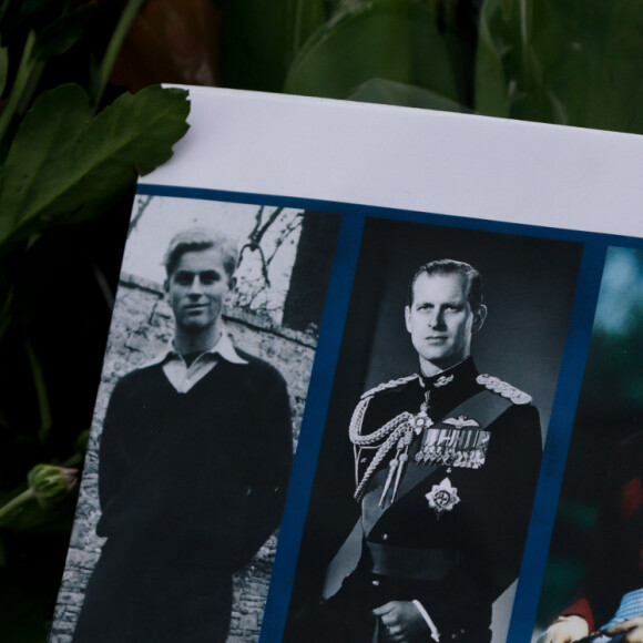 Uma mensagem de homenagem ao príncipe Philip da Grã-Bretanha é vista em meio a flores do lado de fora do Palácio de Buckingham em Londres, Reino Unido