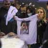 Viúva de MC Kevin, Adeolane Bezerra estende camisa com rosto do cantor estampado em funeral