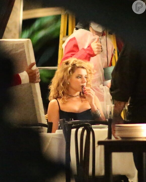 Bruna Linzmeyer se senta na mesa do restaurante da Zona Sul do Rio para gravar cenas da novela 'Pantanal'
