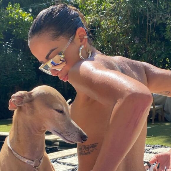 Anitta dispensou a parte de cima do biquíni para tomar sol em sua casa nos EUA