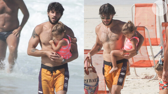 Chay Suede é flagrado na praia do Rio com a filha mais velha no colo