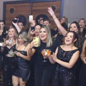 Natália Toscano, mulher de Zé Neto, aparece com look prateado em meio aos convidados, todos vestidos de preto