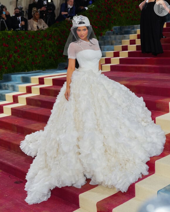 Kylie Jenner usou look all white com boné, plumas e transparência