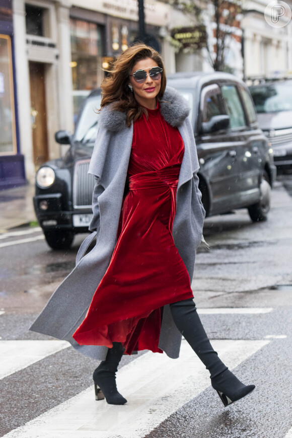 Trench coat cinza faz contraponto ao vestido vermelho poderoso da atriz Juliana Paes em dia de frio
