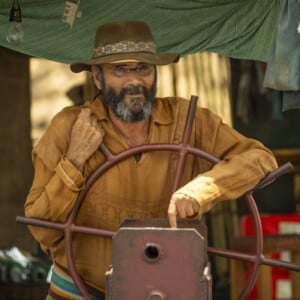 Eugênio (Almir Sater) surpreende Maria Bruaca (Isabel Teixeira) e Alcides (Juliano Cazarré) durante passeio na novela 'Pantanal' dizendo que está procurando piranhas para um caldo