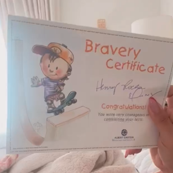 Simone exibiu o 'Certificado de Bravura' conquistado pelo filho, Henry, que aguentou firme as agulhadas