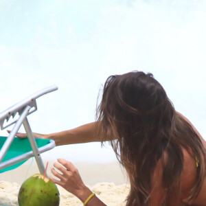 De biquíni, Deborah Secco aproveitou ida à praia para tomar uma água de coco