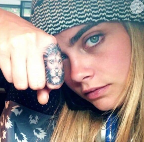 A atriz Cara Delevingne tem o rosto de um leão tatuado no dedo